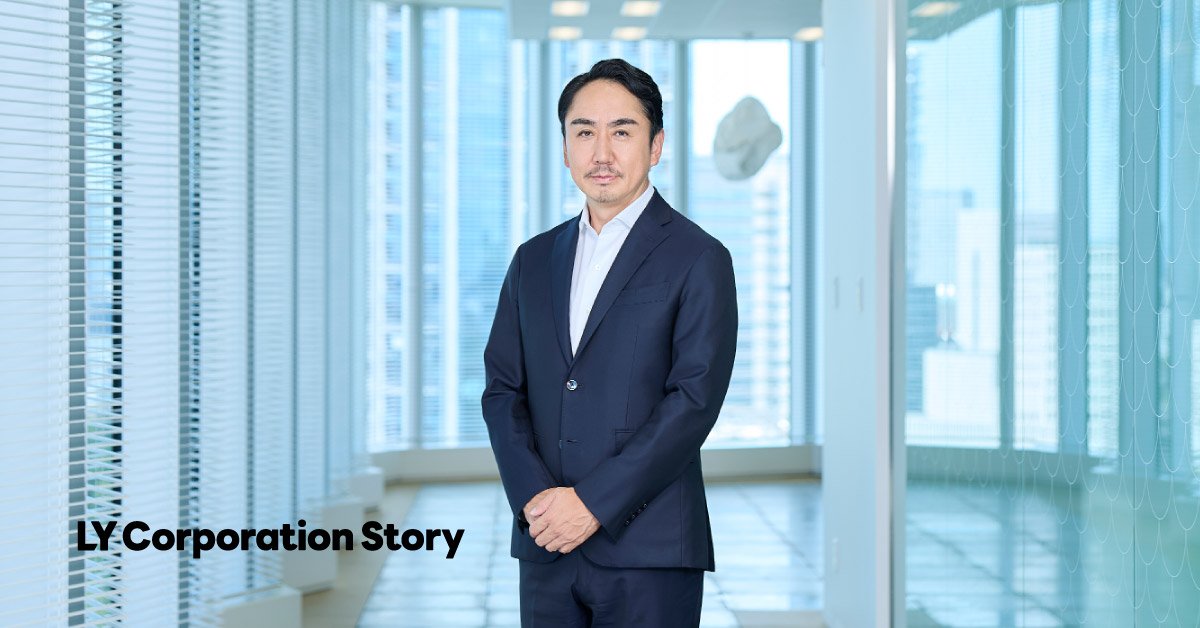 CEO Takeshi Idezawa standing in a bright office wearing a suit. The words 'LY Corporation Stories' appear at the lower left.