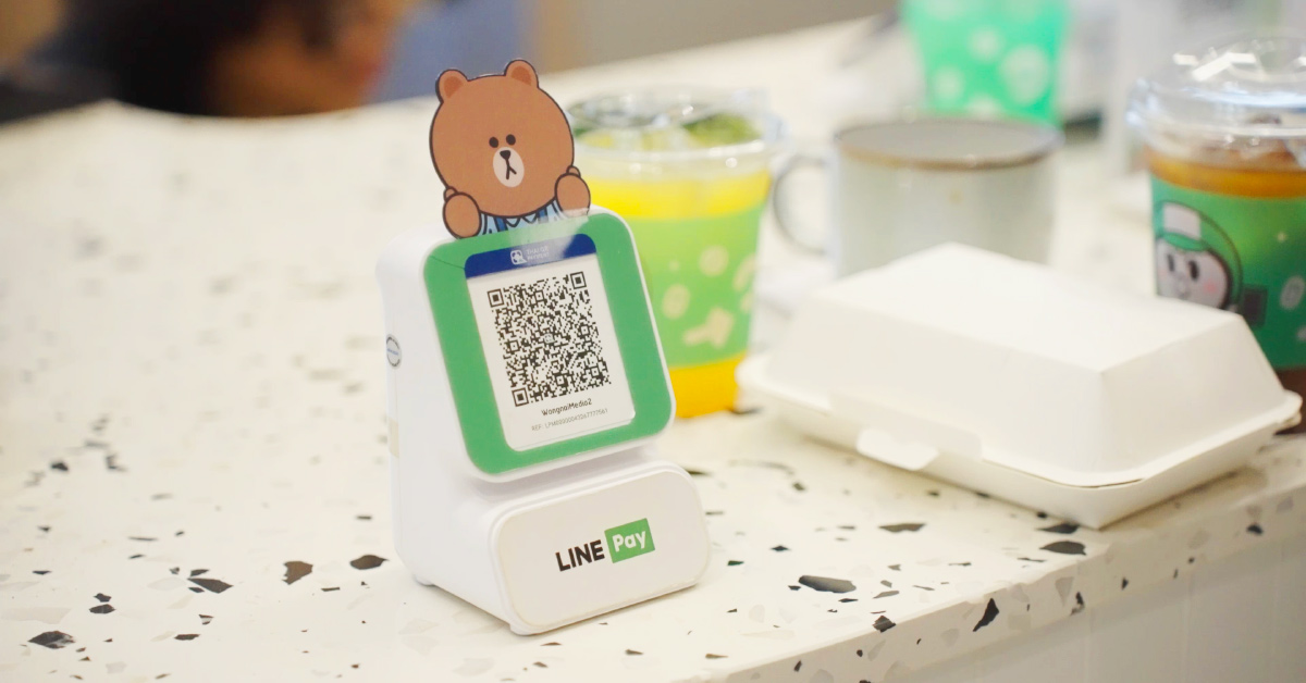 A LINE Pay QR code payment stand sits on a restaurant table.