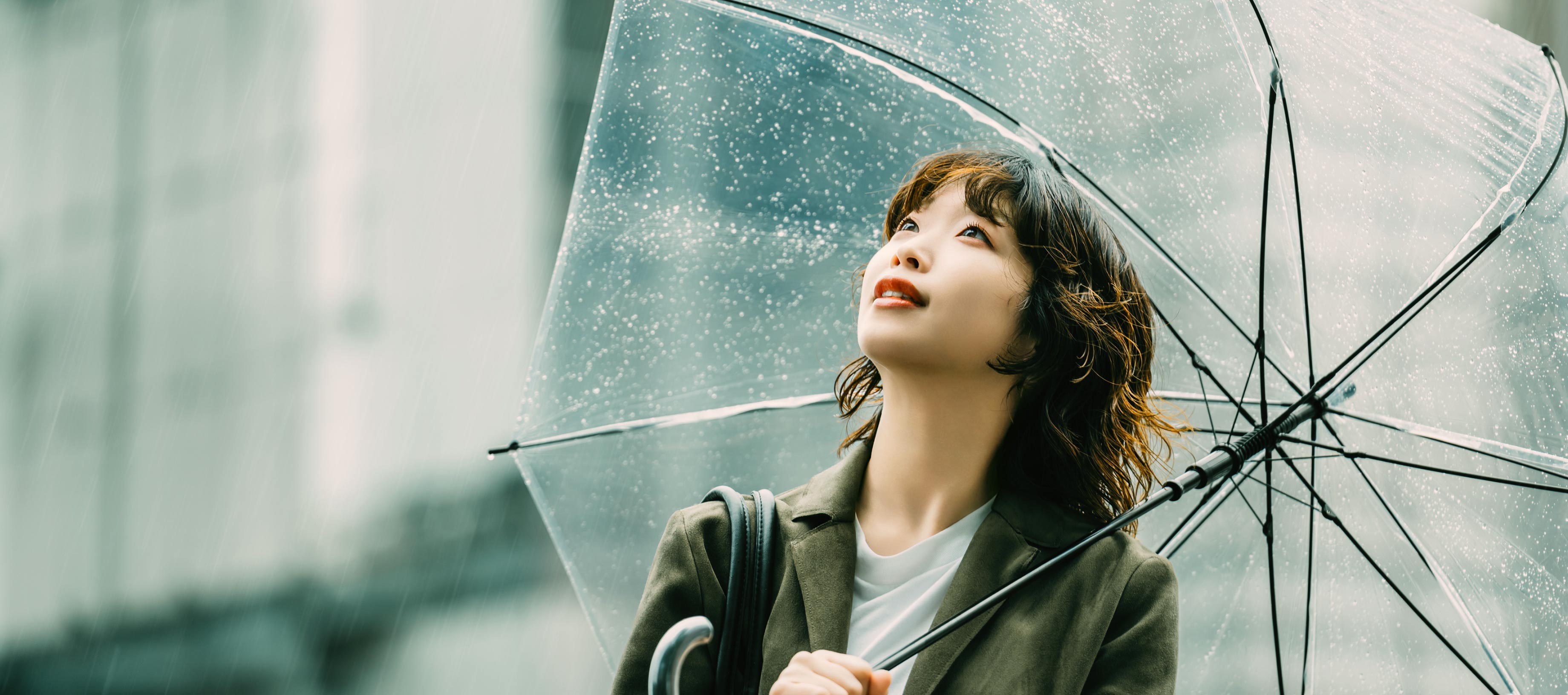 雨の中で透明な傘を差し、希望に満ちた表情で空を見上げる女性。中央にはLINEヤフーのミッション「WOW Our Users!」のテキストが配置されています。