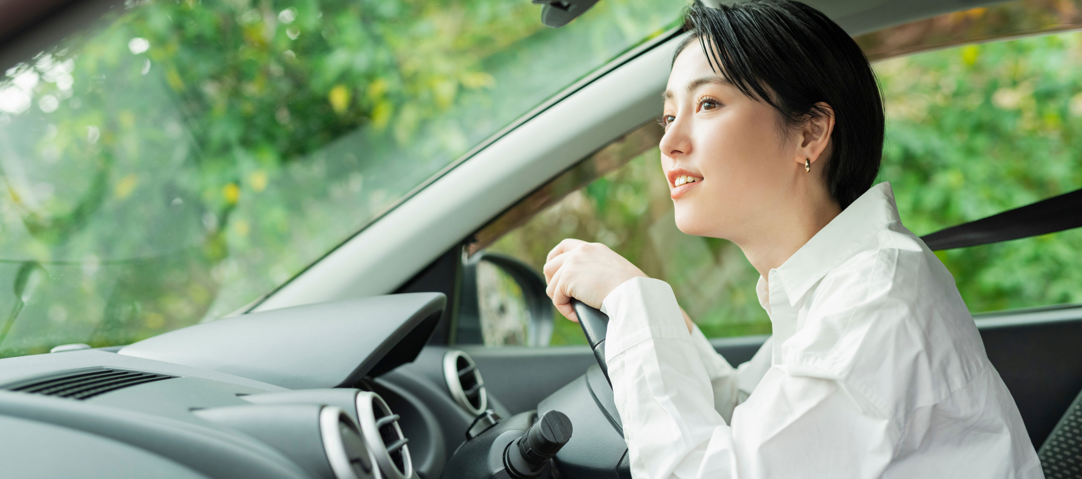 車の運転席でハンドルを握り、真剣な表情で前を見つめる女性。中央にはLINEヤフーのミッション「WOW Our Users!」のテキストが配置されています。