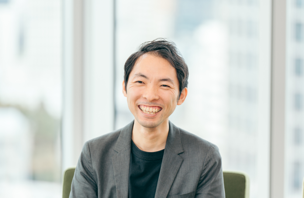 カメラに向かって大きな笑顔を見せている橋本さん。明るく親しみやすい雰囲気が伝わる。