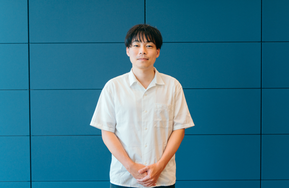 三澤 明寛さんのインタビュー記事の写真です。三澤さんが正面を向いて写っています。
