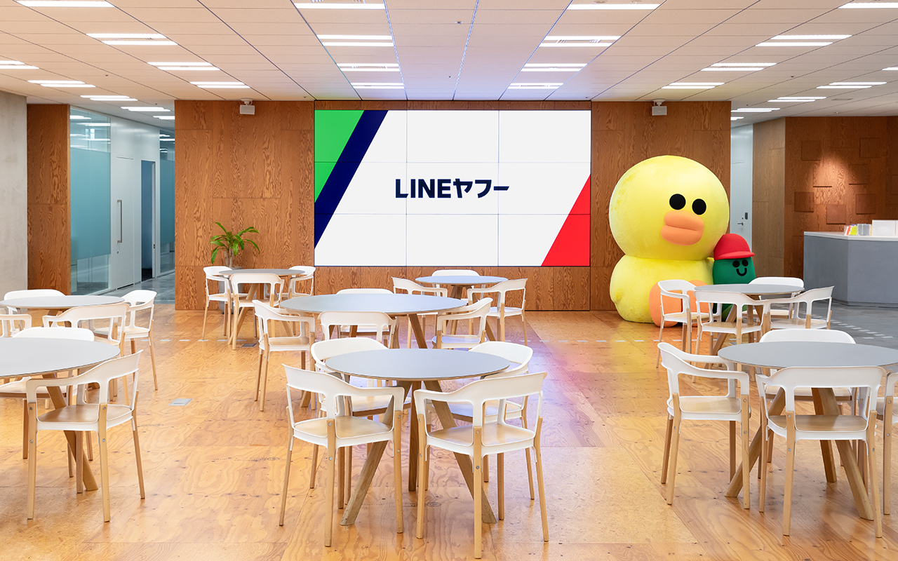 紀尾井町オフィス04 LINEヤフーのロゴが表示されたモニターとキャラクターがあるラウンジスペース