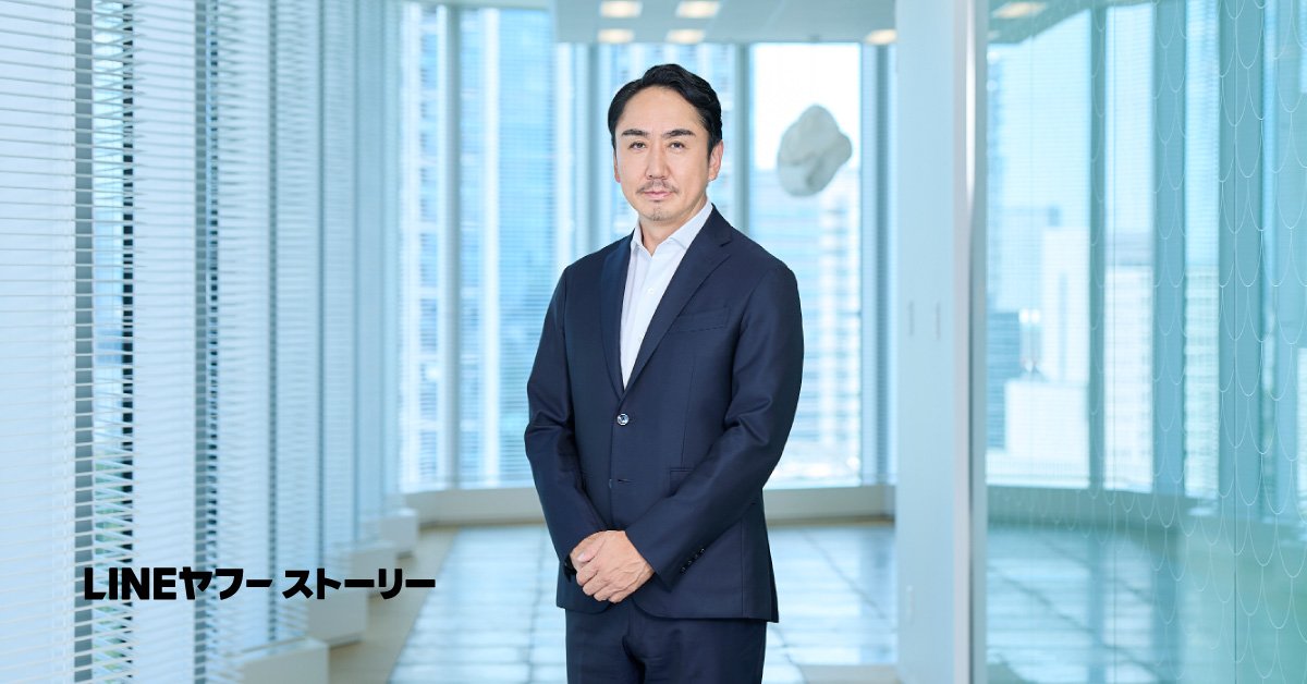 明るい室内で、スーツ姿のCEO出澤が立っている写真。左下に『LINEヤフーストーリー』の文字が表示されています