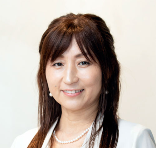 正木CEOのポートレート。白い背景に白いジャケットを着ており、穏やかな表情でカメラを見ています。