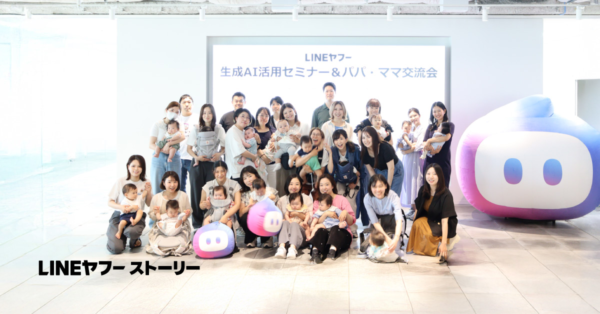 LINEヤフーの生成AI活用セミナー＆パパ・ママ交流会に参加した育休中の社員とその子どもたちの集合写真。背後には「LINEヤフー 生成AI活用セミナー＆パパ・ママ交流会」と書かれたパネルが掲示されている。多くの参加者が赤ちゃんを抱っこしたり膝に乗せたりしている。