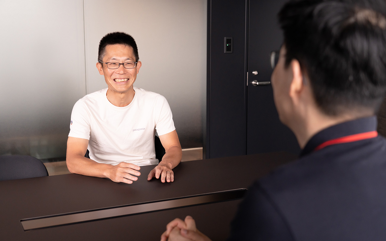 朝井が正面を向いて会話している様子