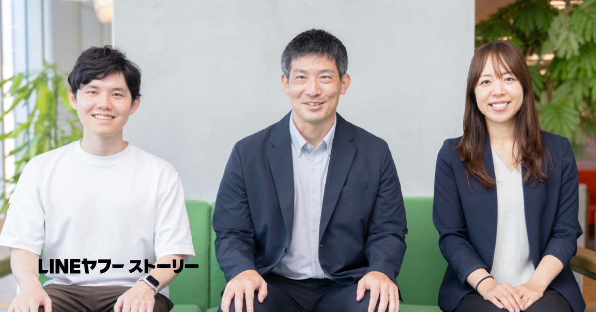 白いTシャツの若い男性、スーツ姿の男性、ジャケットを着た女性の3人が並んで緑のソファに座り、正面を向いて笑顔を見せている。左下に「LINEヤフーストーリー」と文字が表示されている