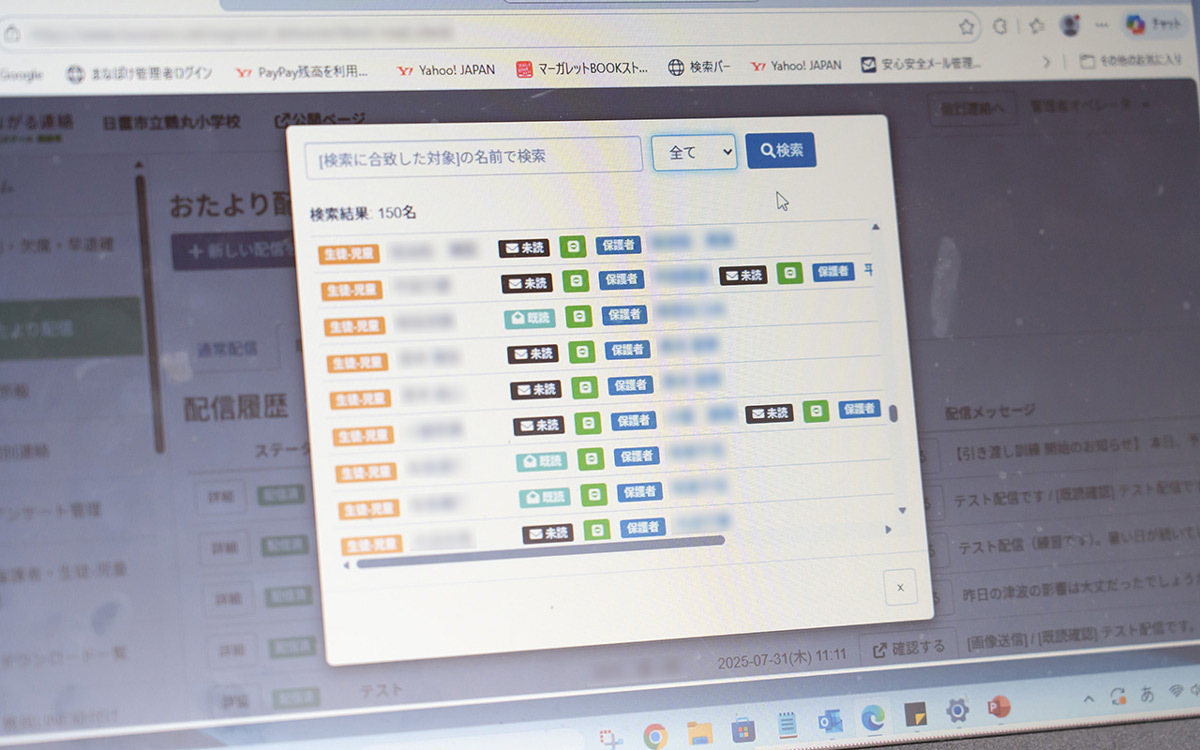 パソコンのブラウザ上に表示された学校向けの連絡管理システムの画面で、中央に検索結果一覧のポップアップが表示されている様子の写真。ポップアップ上部には検索欄と「検索」ボタンがあり、その下に複数の利用者名が一覧形式で並んでいる。