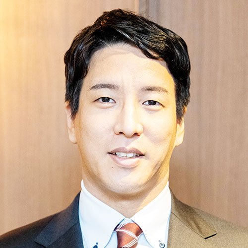 スーツ姿の金剛洙さんのプロフィール写真。短い黒髪で、穏やかな表情を浮かべて正面を向いている