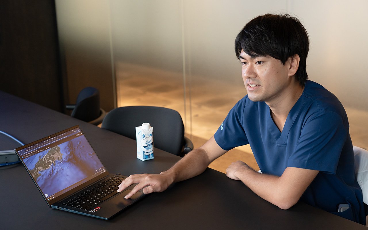 Yahoo!天気アプリの雨雲レーダーを見ながら説明する徳田充宏さん