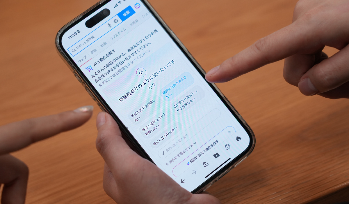 携帯の画面に「Q1:掃除機をどのように使いたいですか？」と質問が表示されている画像