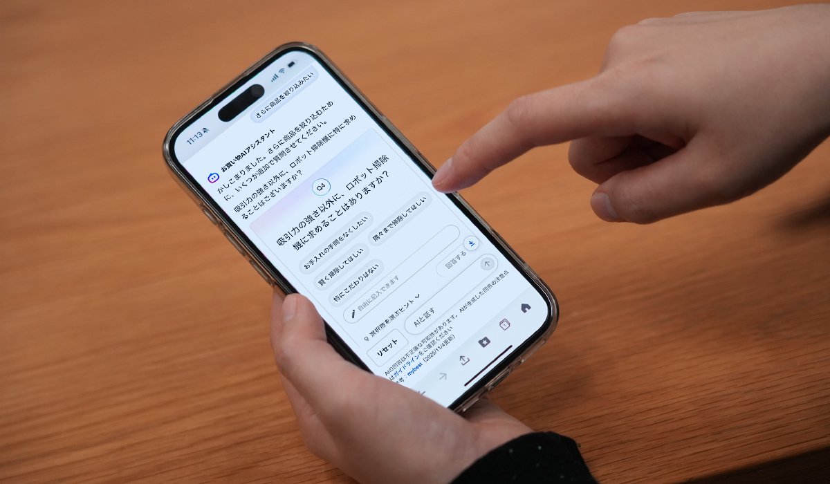 携帯の画面に「Q4：吸引力の強さ以外に、ロボット掃除機に求めることは？」と表示がされている画像