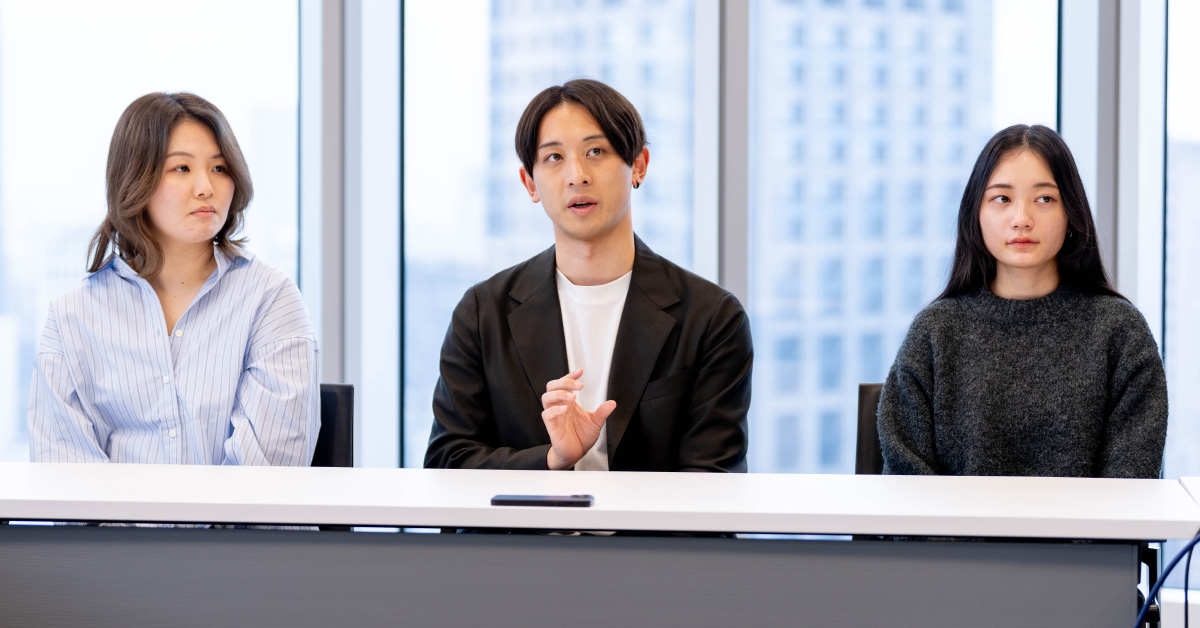タスクフォースメンバー3人が横並びで座り、座談会に参加している写真。明るい会議室で、それぞれが真剣な表情を見せている。