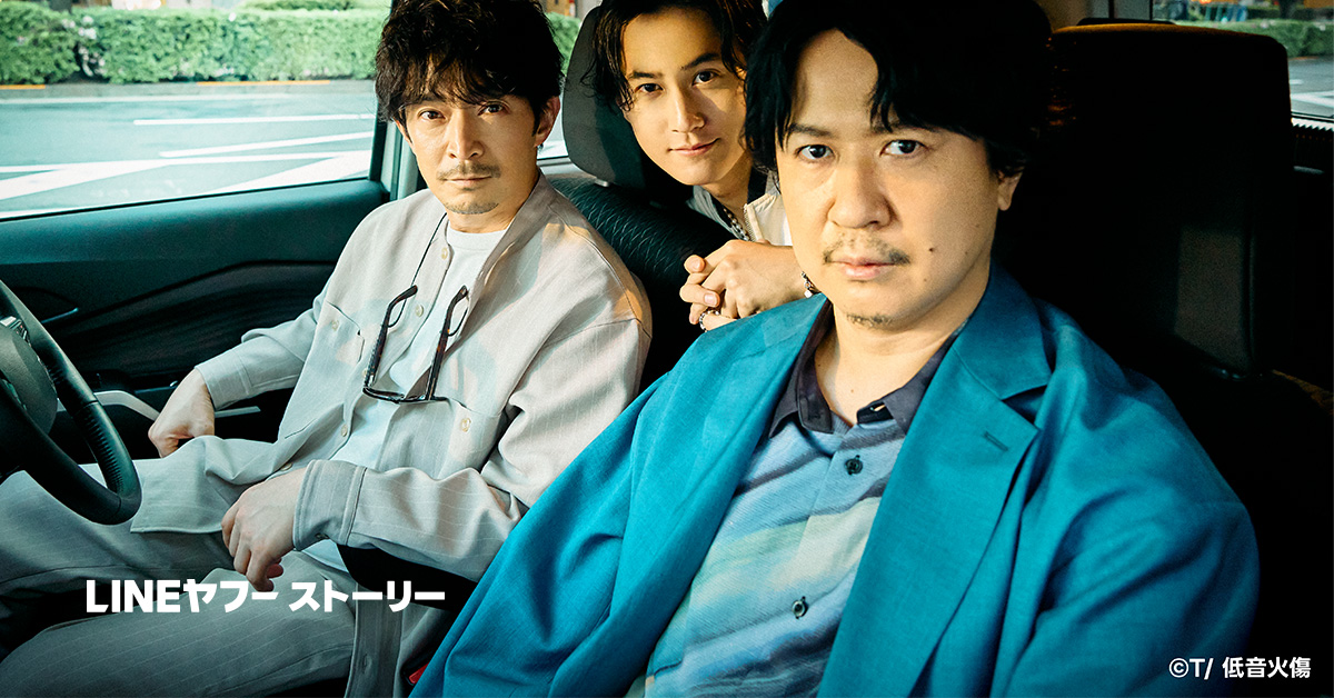 車の中で3人の男性が座っており、カメラを見つめています。