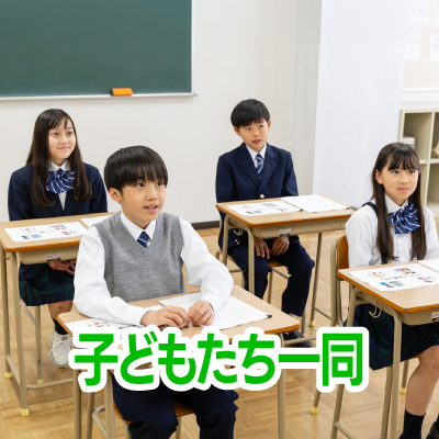 教室で生徒たちが机に座り、前を向いて授業を受けている様子です。皆、真剣に話を聞いています。