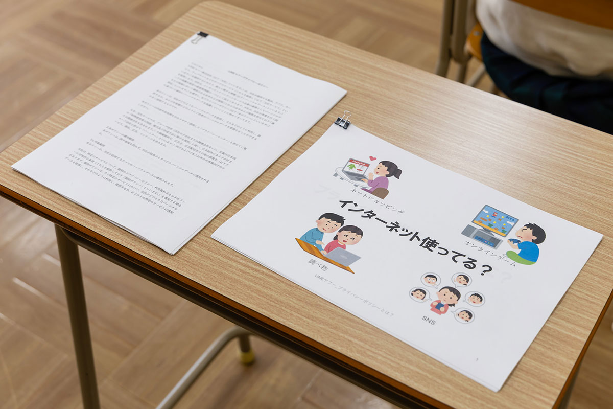机の上に置かれたプリントのクローズアップです。「インターネット使ってる？」というタイトルの資料が見えます