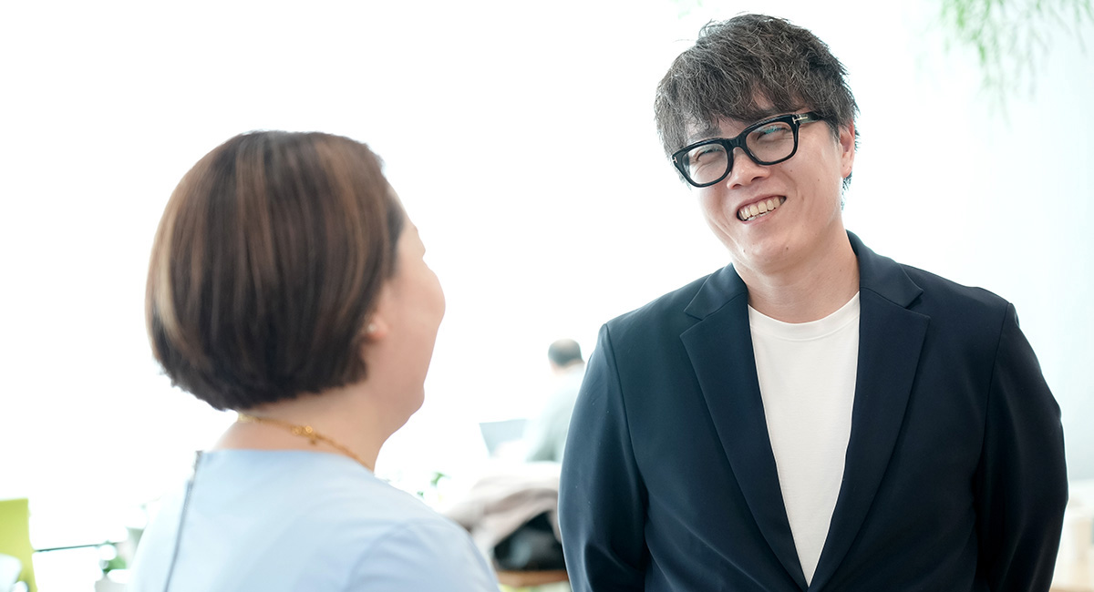 番場と寺澤が笑顔で会話している様子です。