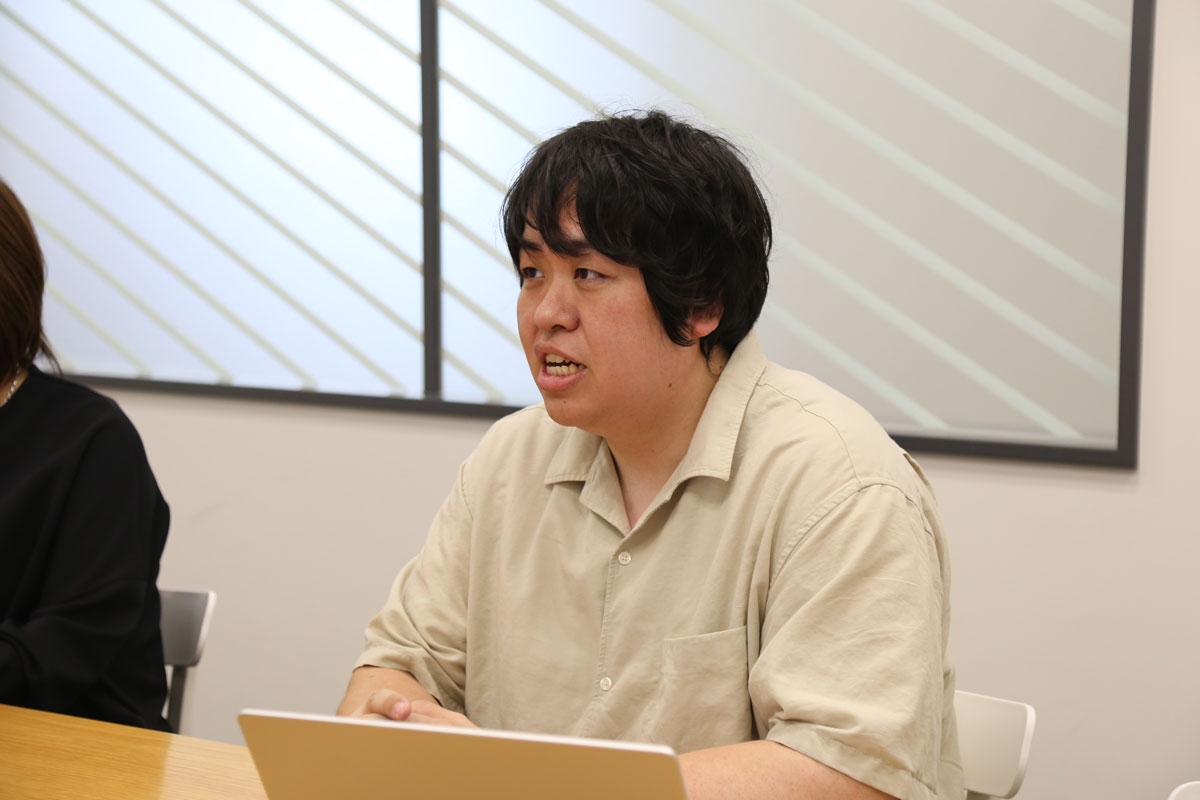 会議室で取材を受ける山田