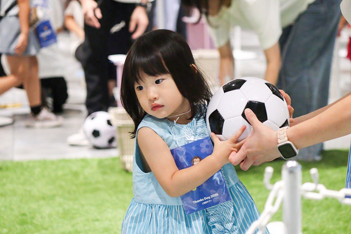 子どもがボールを手に、39サッカーに挑戦している写真
