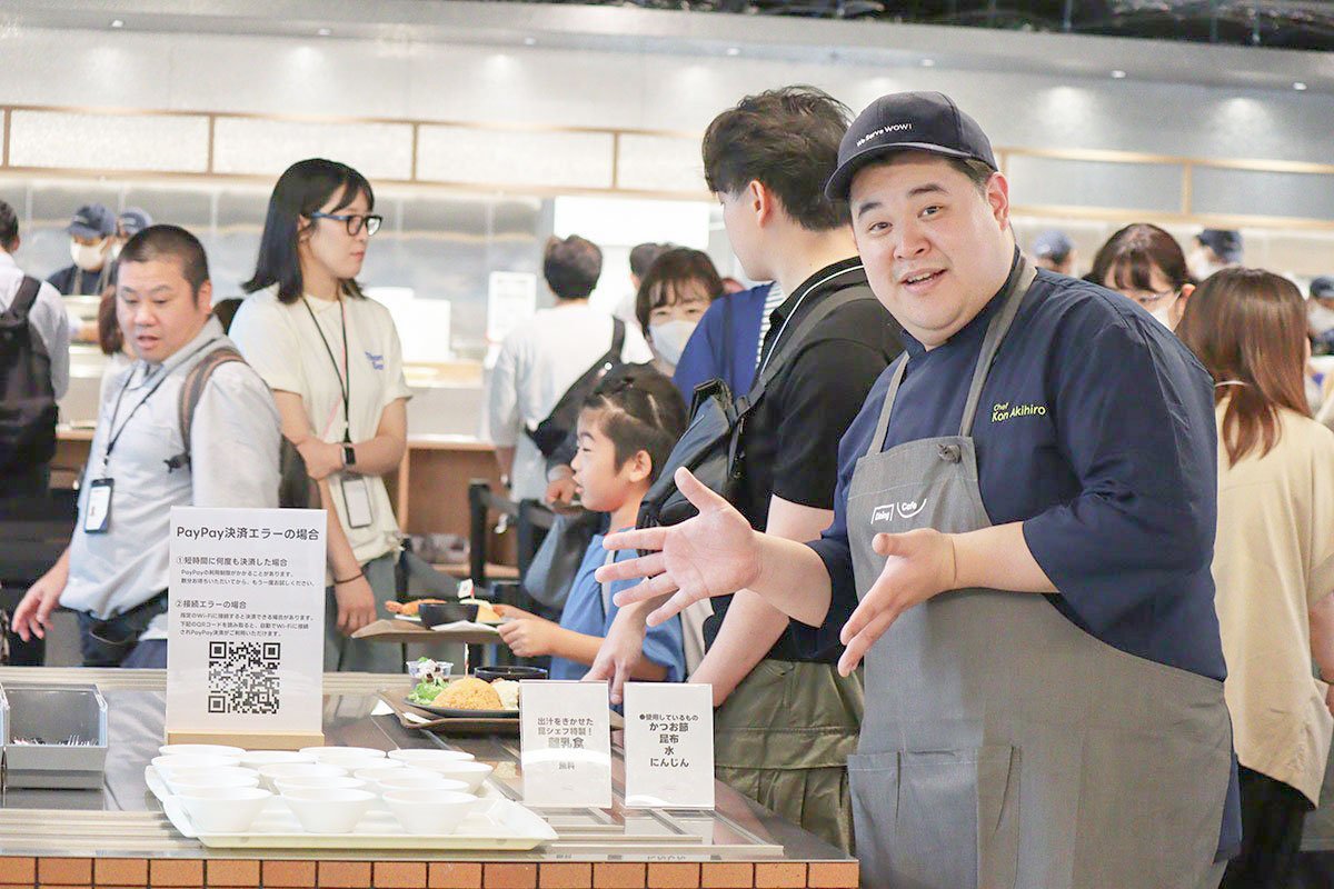 Diningでスタッフが料理を提供し、家族連れのゲストが食事を選んでいる写真