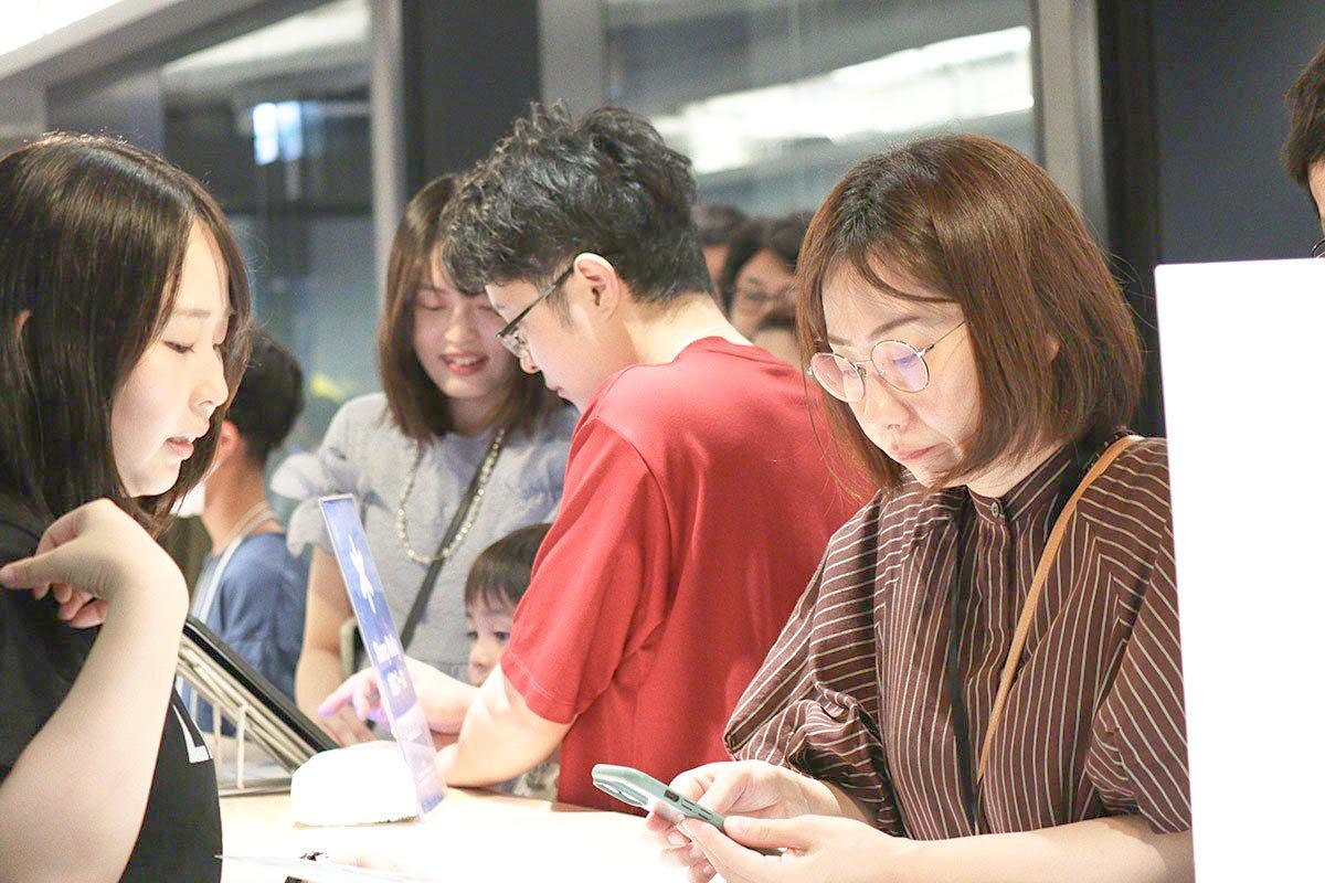 LINEバイトの診断体験ブースで、北島がパソコンを操作しながらゲストに説明している写真
