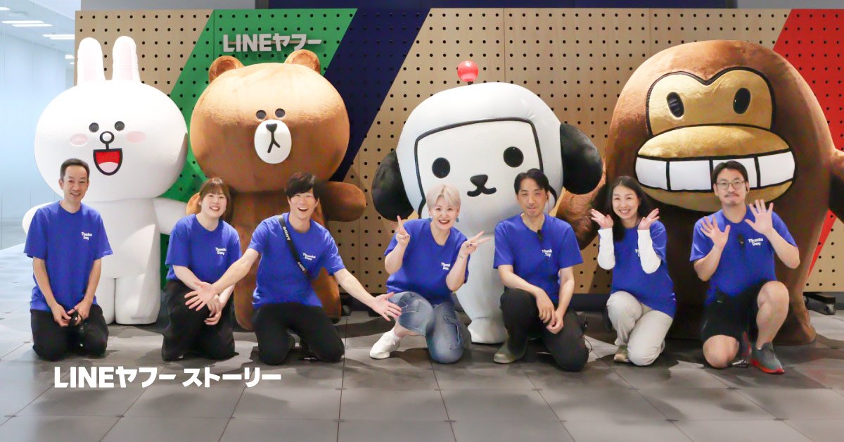 LINE FRIENDSのキャラクターとけんさくとえんじんの前に、Thanks Dayの社員スタッフが並んでいる写真