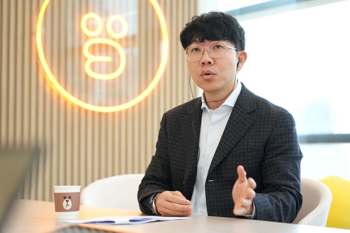 黒いスーツを着たネイトさんが、インタビュアーに語り掛けている様子です