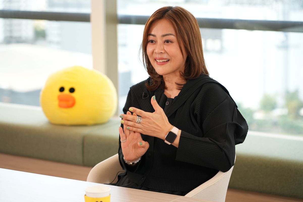 エイさんが笑顔で話している様子。LINEキャラクターの人形が後ろにある。