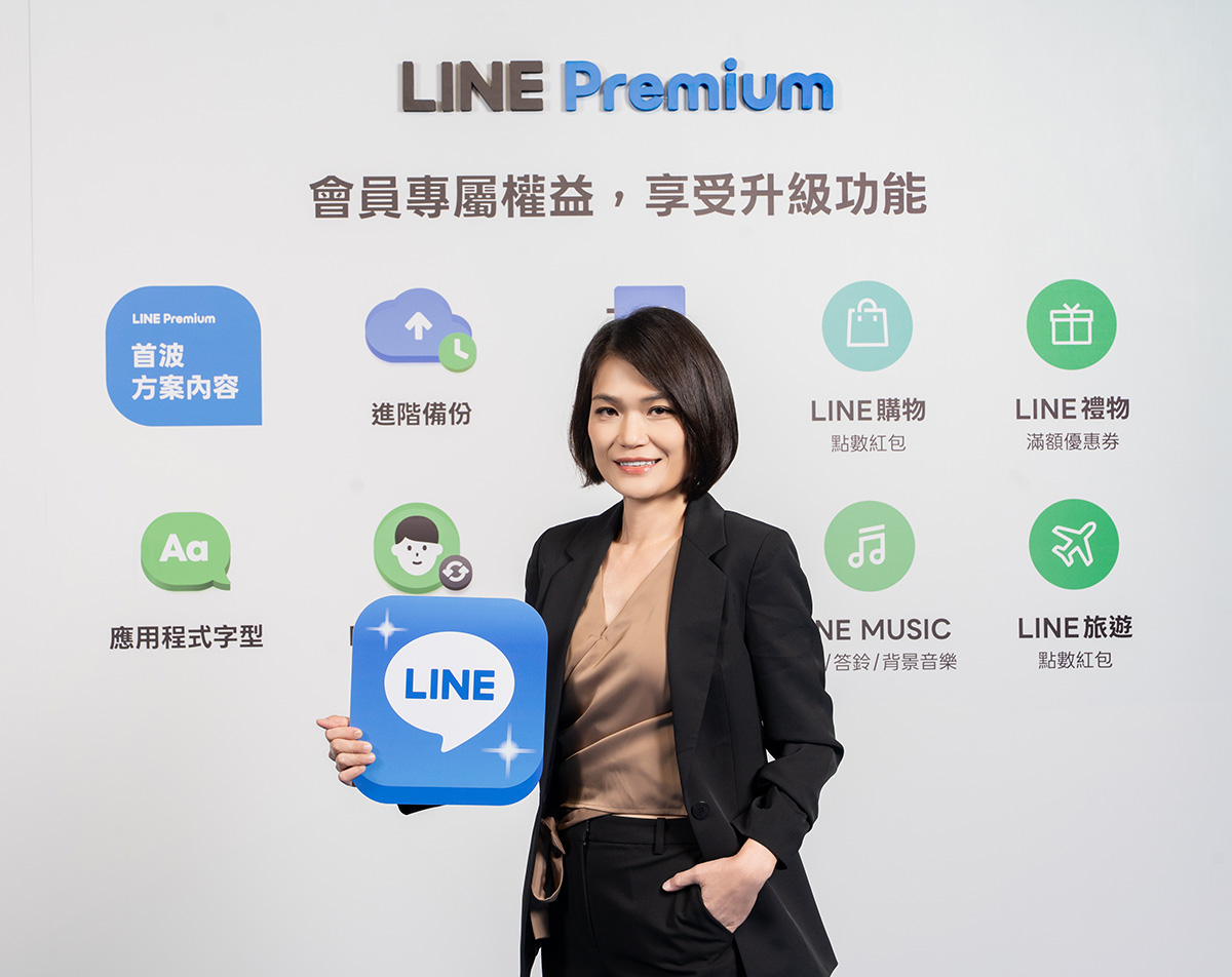 ジャニスが正面を向いて青いLINEのアプリアイコンのパネルを持っている写真