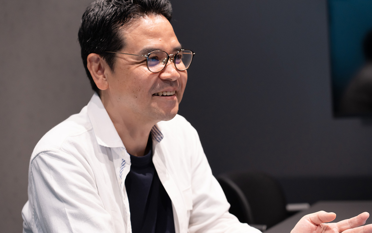 田中が笑顔で会話している様子