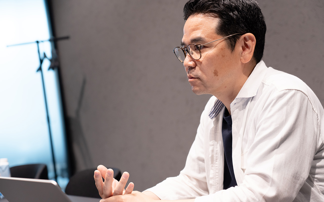 田中がノートパソコンに向かいながら話している様子