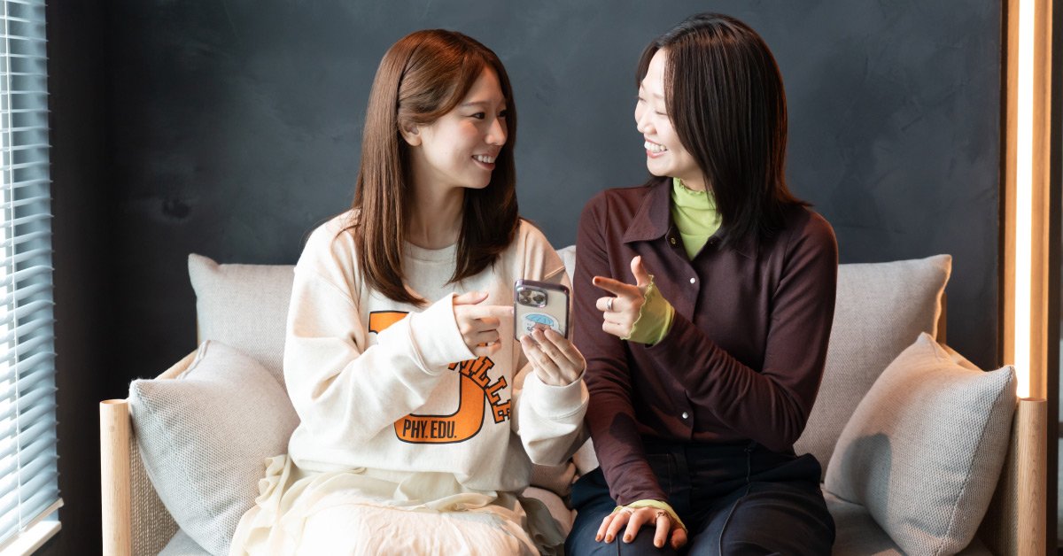 スマートフォンで天気コーデを見る舩橋沙貴さんと井澤咲乃さん
