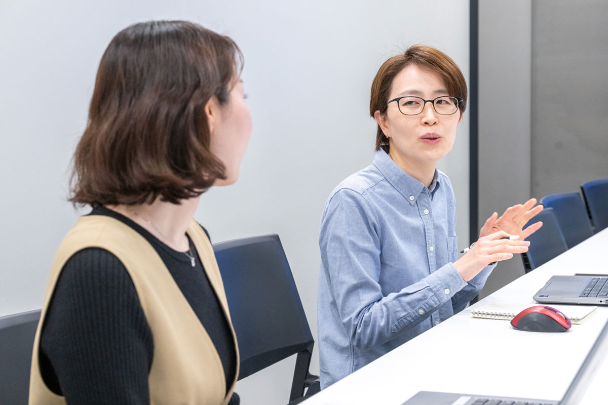会議室でインタビューに答える金と渡部の写真