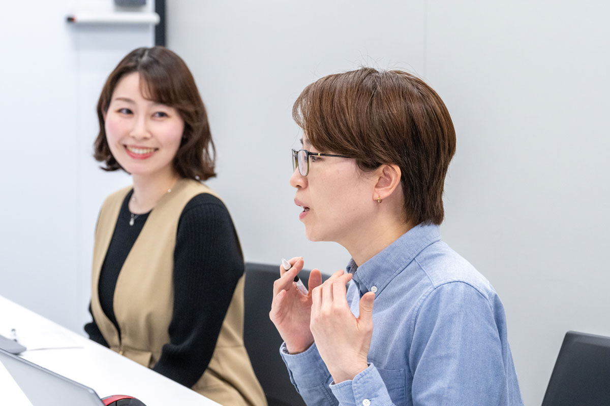 会議室でインタビューに答える金と渡部の写真